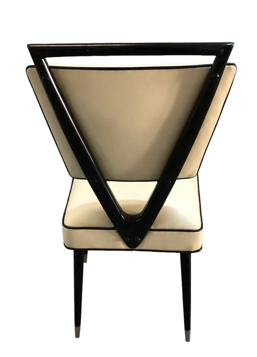 Vista trasera de 2 sillas antiguas con diseño triangular en la parte posterior, en un ambiente minimalista.