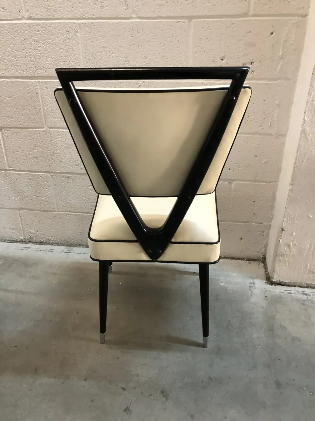 Vista traseira de duas cadeiras antigas com design único, parte de um ambiente elegante.