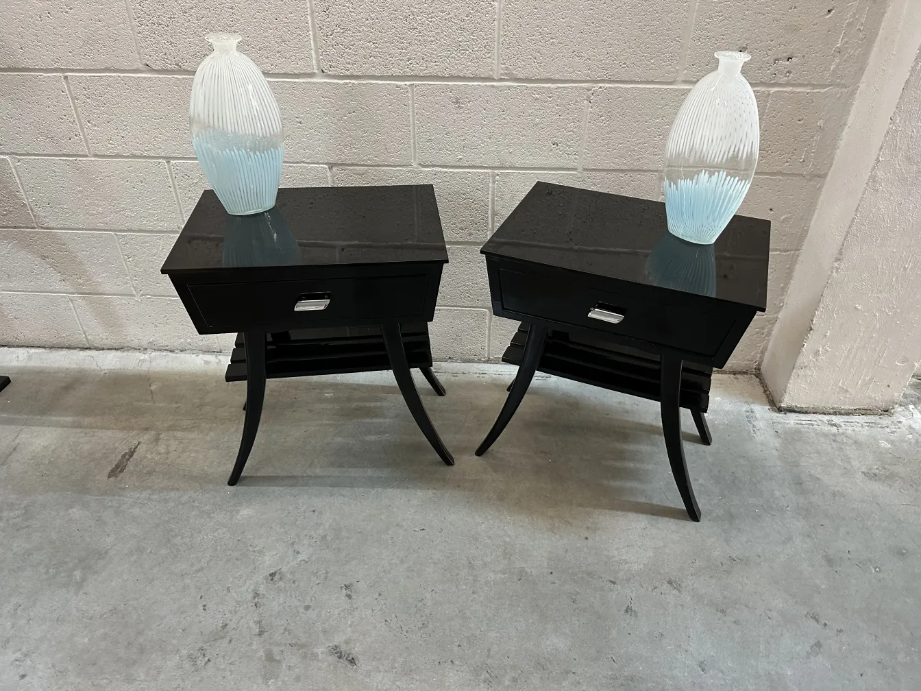 Conjunto de mesas de luz antigas com vasos decorativos.