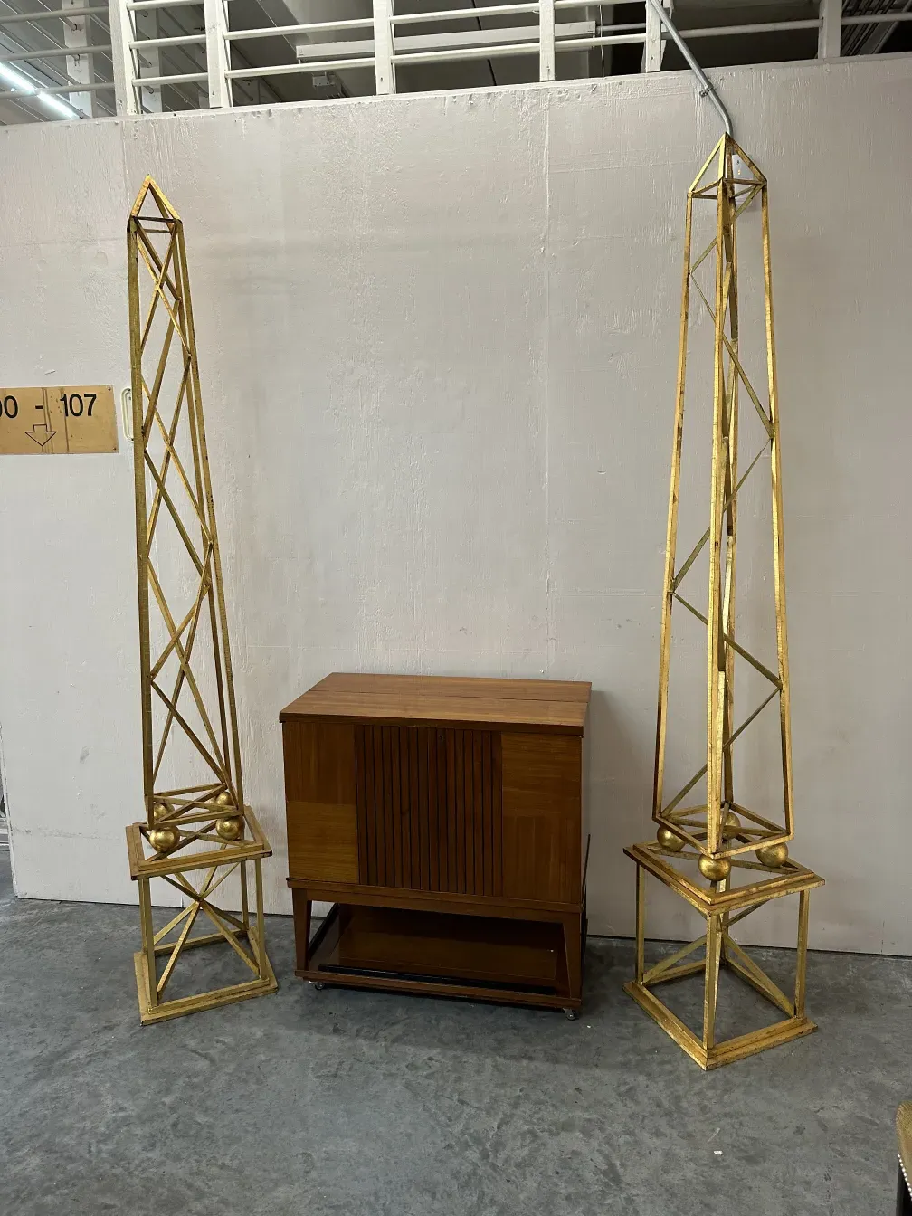 two antique obelisks with decorative details in a neutral setting