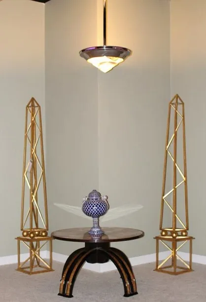 dos obeliscos dorados junto a una mesa decorativa