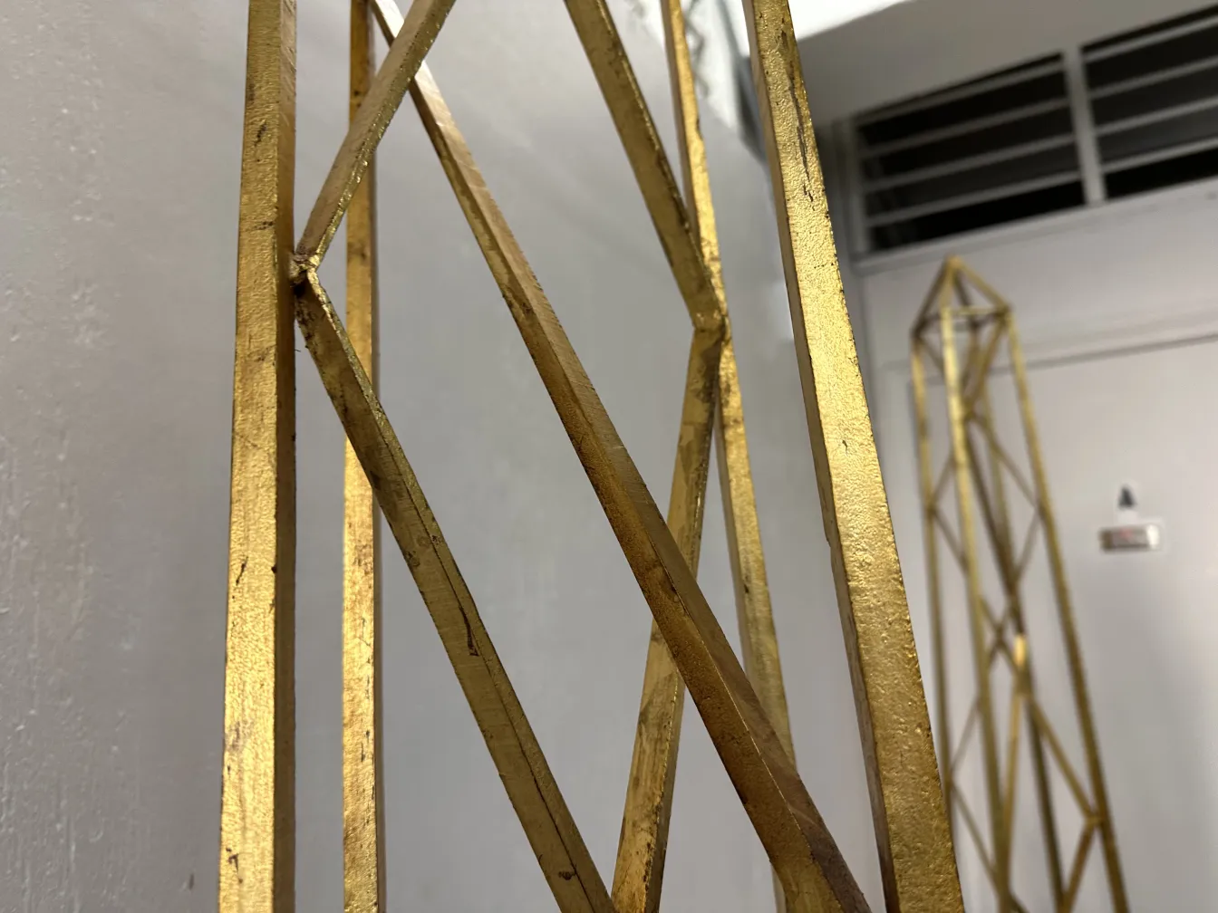 Dos obeliscos antiguos decorativos en un entorno neutral.