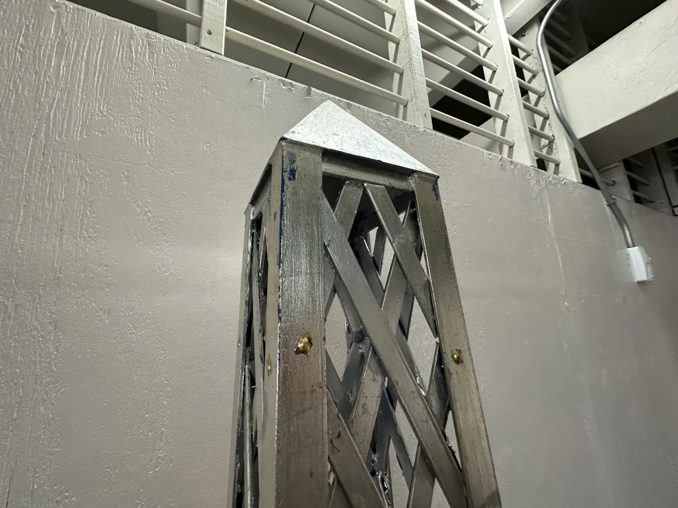 Obelisco antigo com detalhes decorativos em um ambiente moderno.