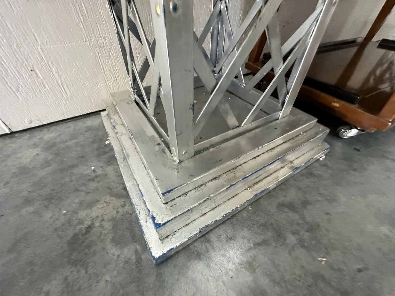 antiker dekorativer Obelisk mit breitem Sockel und elegantem Design in dunkler Umgebung