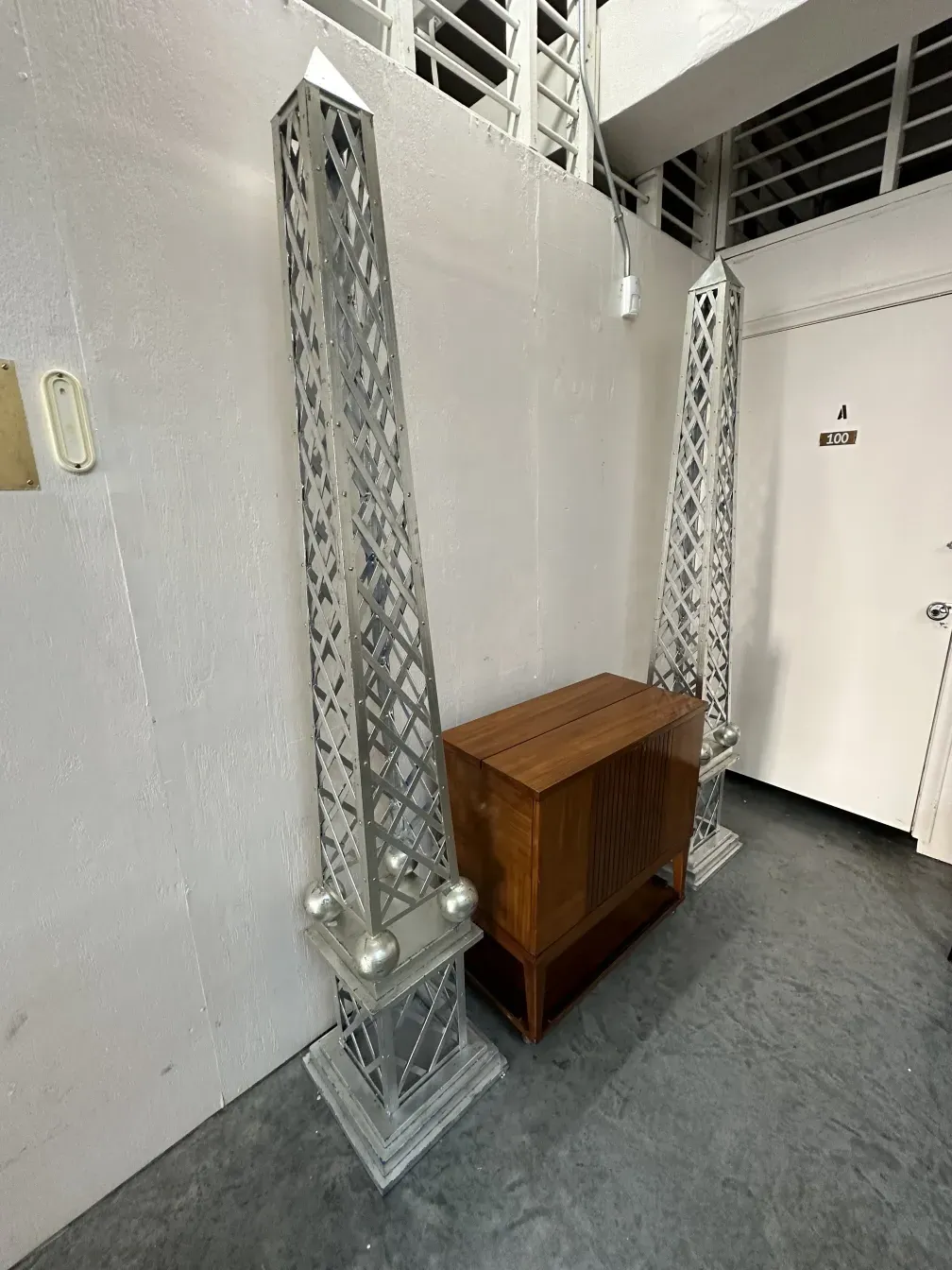 Antique obelisk with decorative design in a garden, simple background