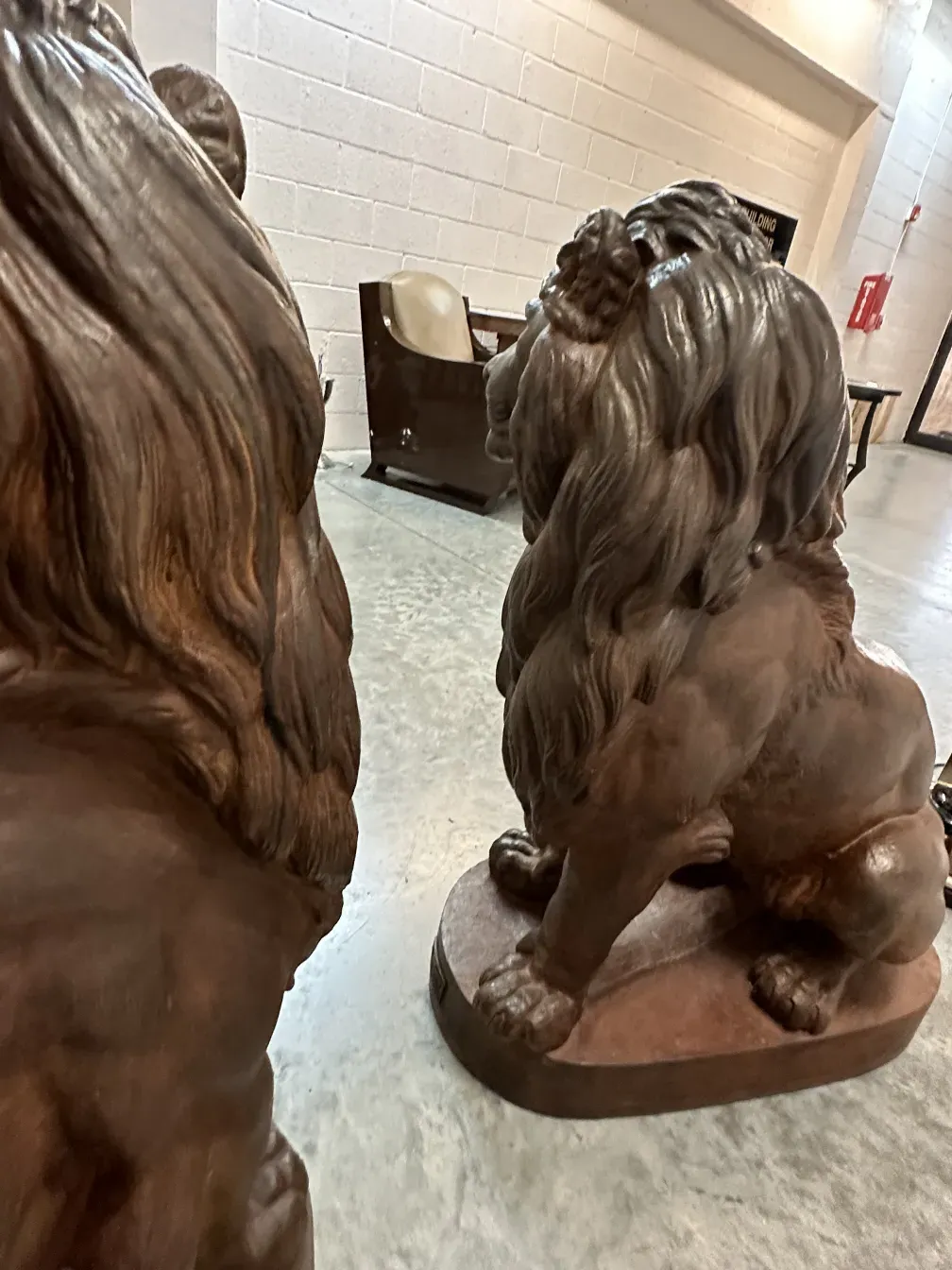 Scultura antica di due leoni in un ambiente classico.