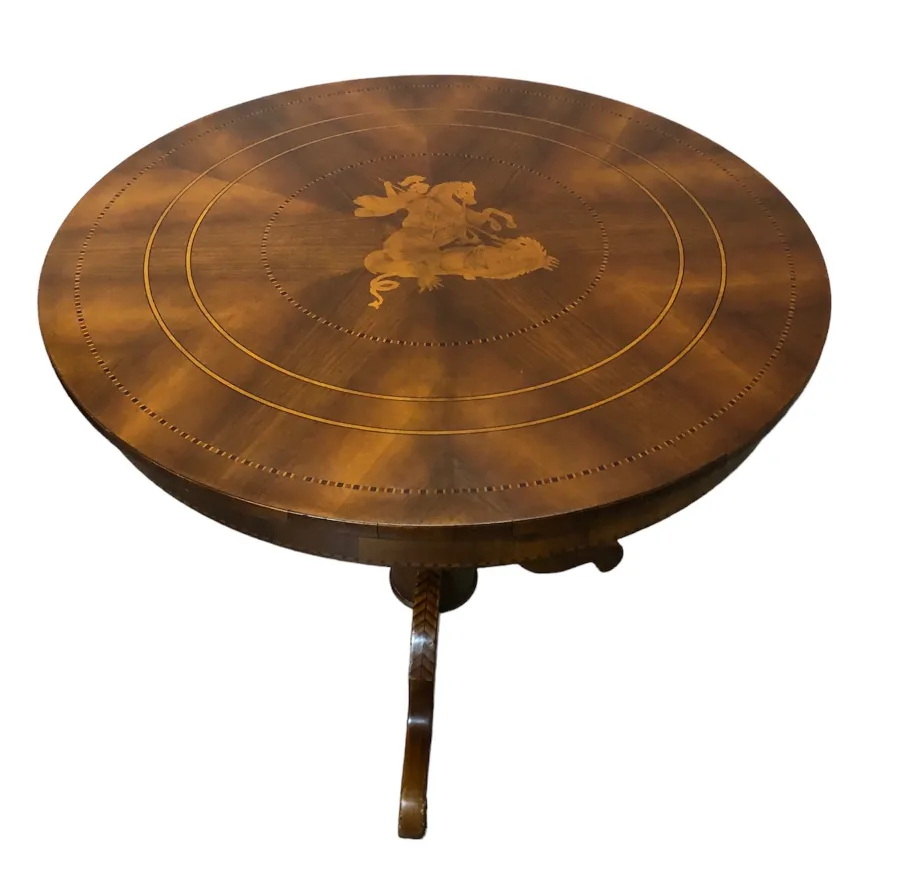 mesa antigua redonda con un intrincado diseño en la parte superior