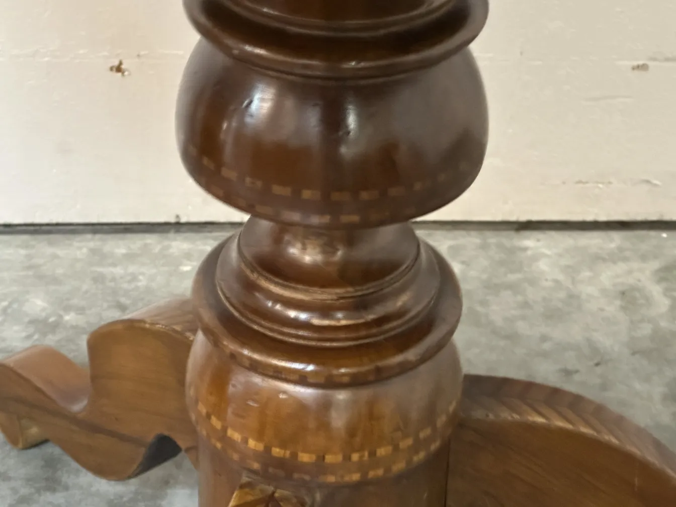 detalhe de uma mesa antiga com base esculpida