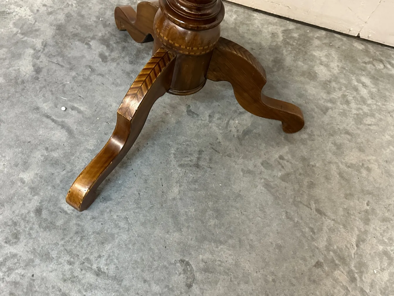 table ancienne avec pieds sculptés dans un environnement neutre