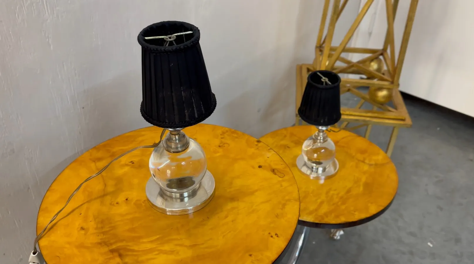 zwei antike Tischleuchten mit schwarzen Schirmen und metallischen Basen, in einem eleganten Ambiente dekoriert