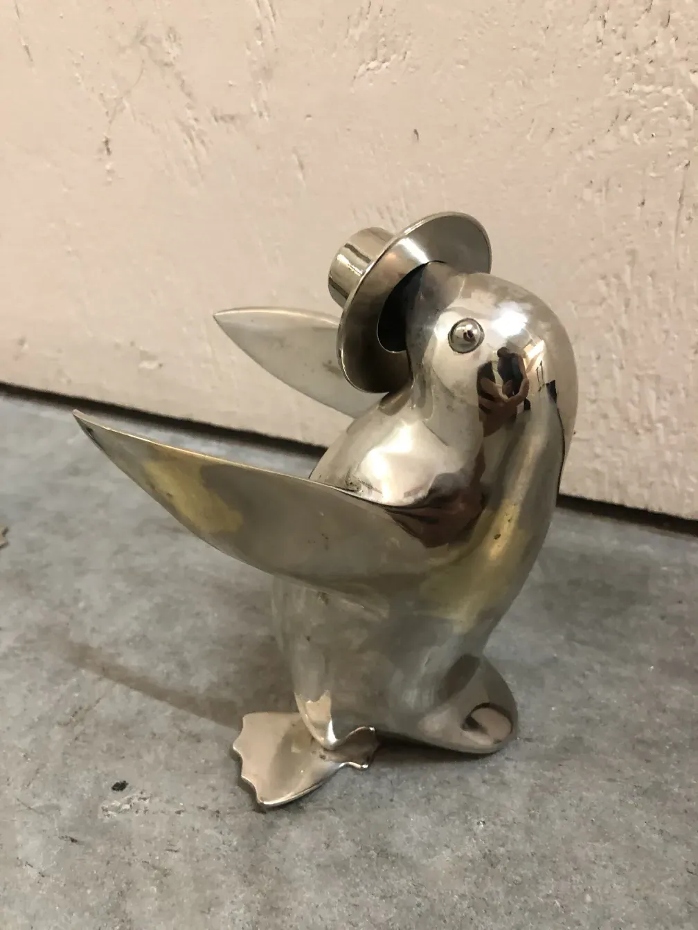 Escultura antigua de dos pingüinos de aspecto estilizado.