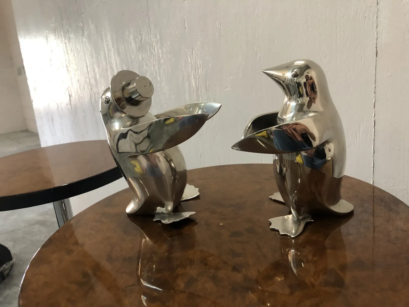zwei antike glänzende Pinguinfiguren auf einem Tisch