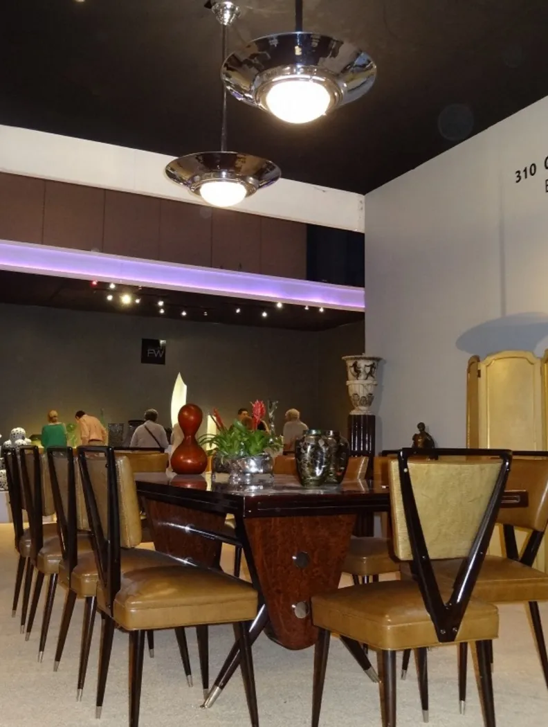 Tavolo da pranzo antico di Carlo Mollino per 10 persone, circondato da sedie. Ambiente elegante.