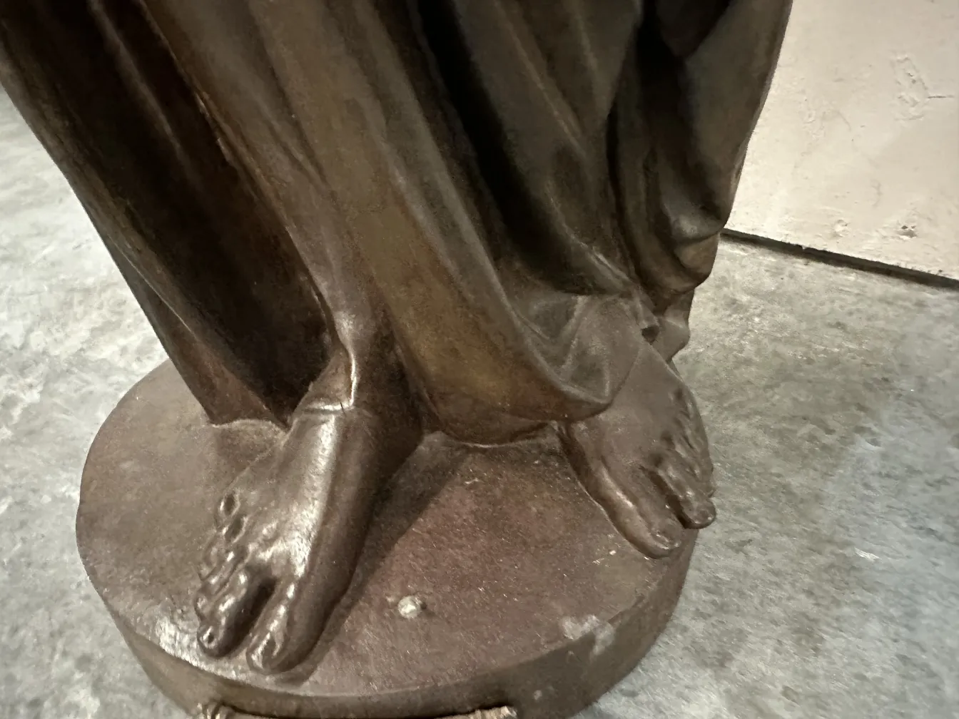 Details of antique sculpture with visible feet and drapery