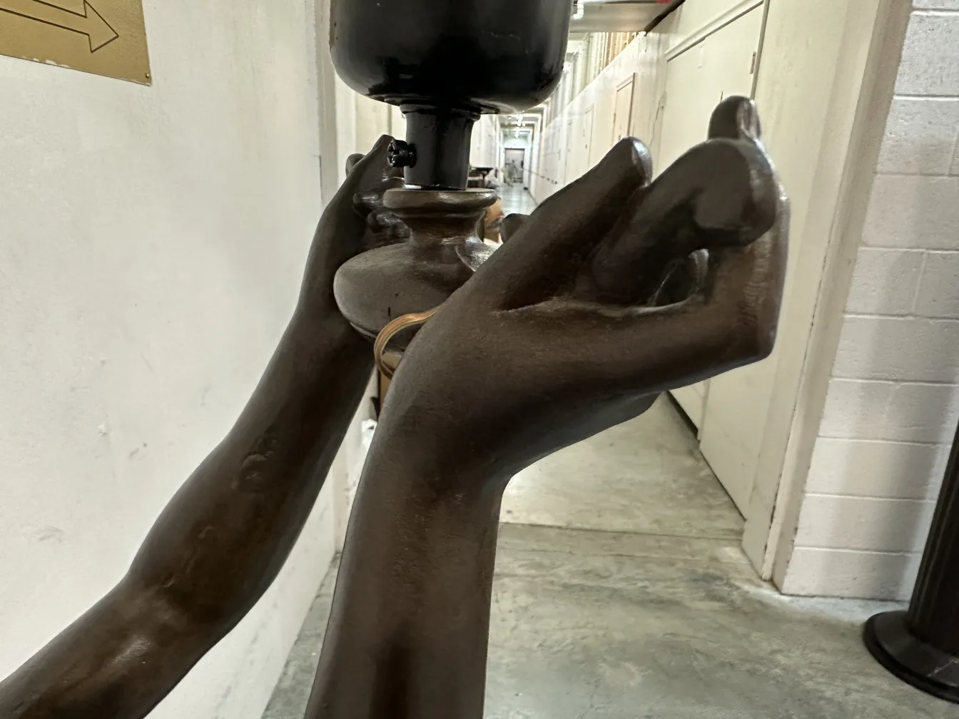 sculpture ancienne avec mains expressives dans un cadre éclairé