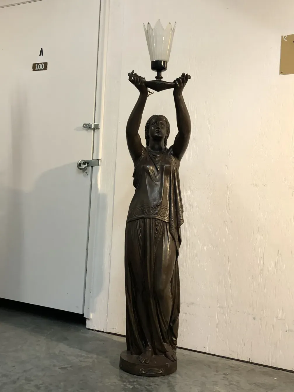 Scultpure ancienne Val D´Osne avec lumière, figure élancée dans un cadre simple.