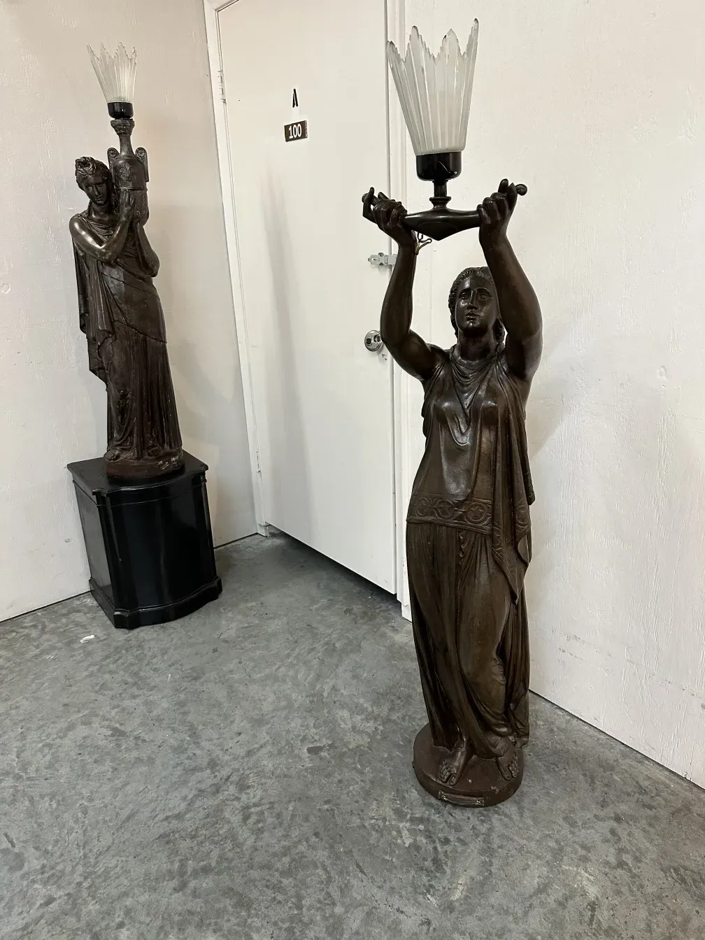 antique sculpture of a female figure holding a light