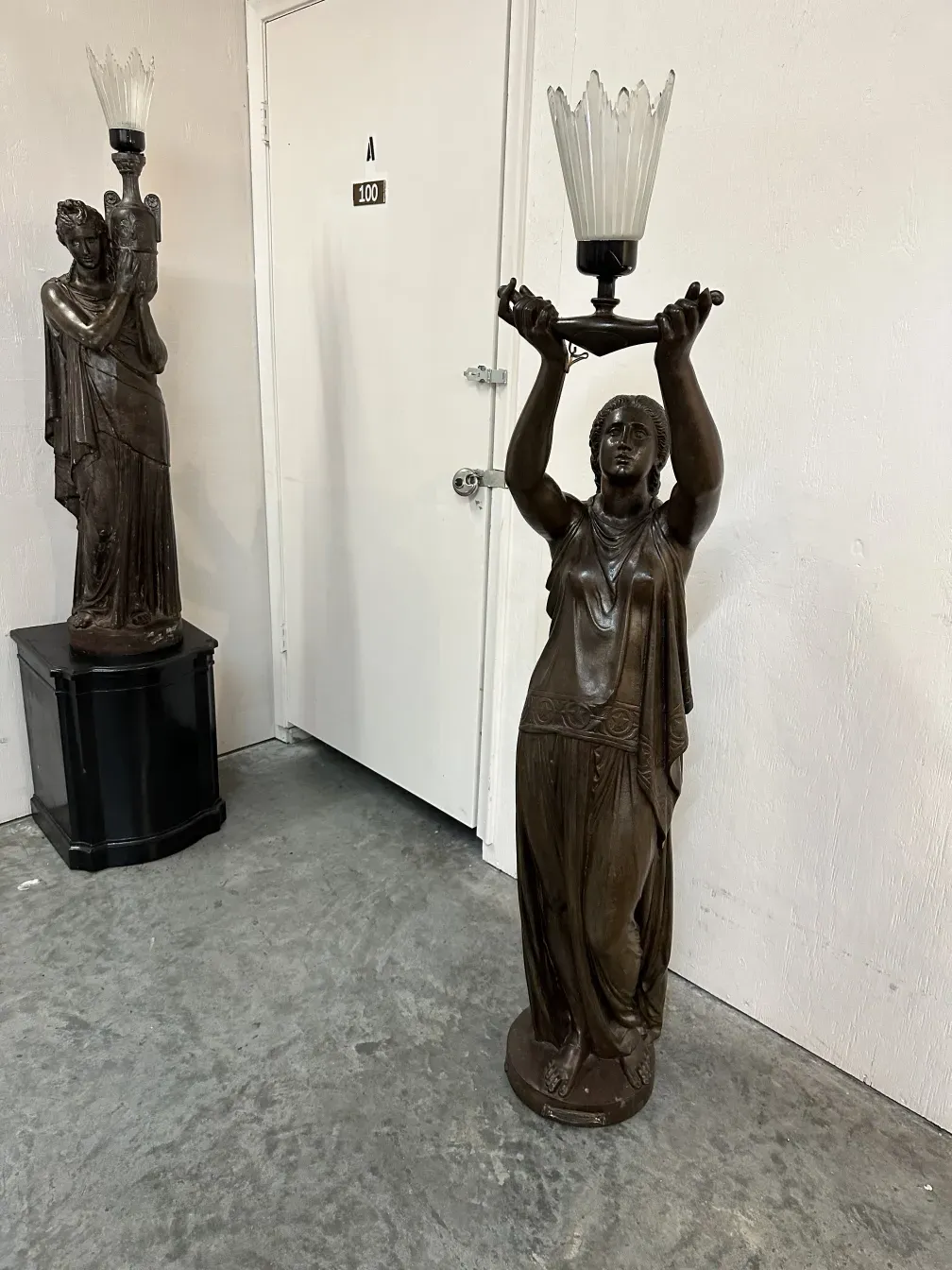 sculpture ancienne d'une figure féminine tenant une lampe