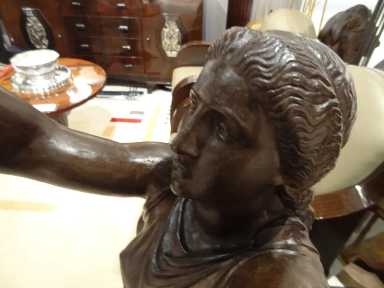 scultura antica val d'osne, figura con espressione delicata, sfondo decorativo