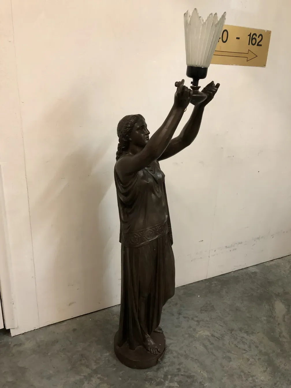 escultura antiga segurando uma lâmpada, figura feminina, elegante