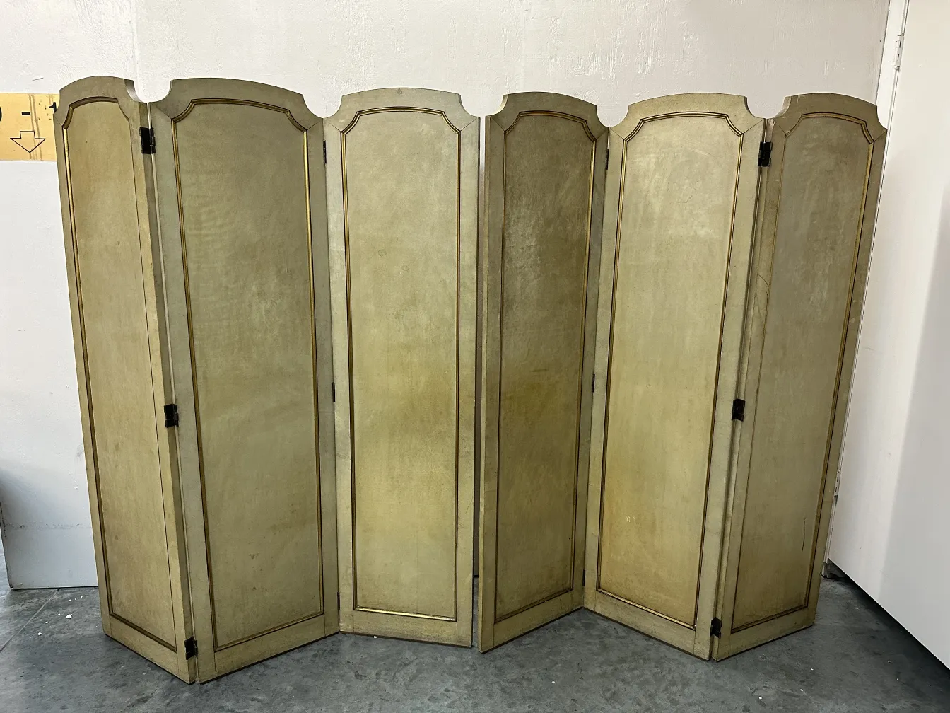 Two antique folding screens with decorative light colors and details.