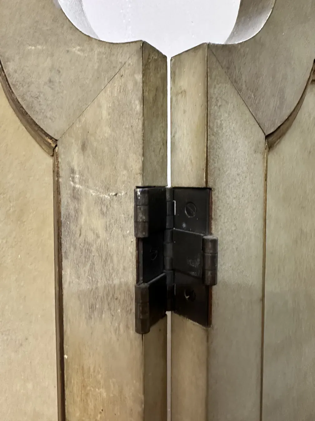 Detail von zwei antiken Paravents mit markantem Design und stabilen Beinen.