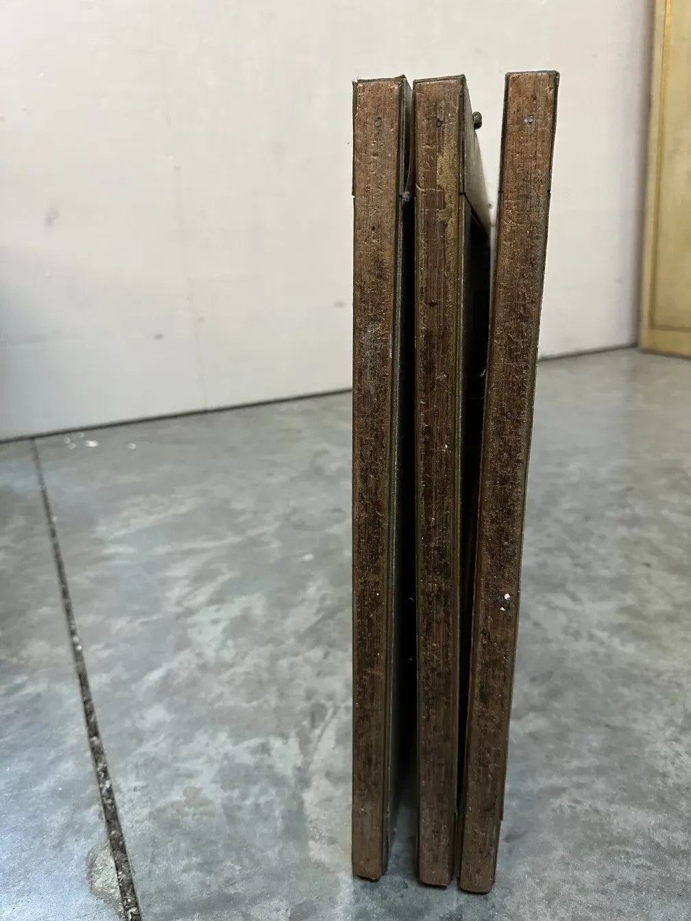 Seitenansicht von 2 antiken Paravents mit Randdetails in einer neutralen Umgebung.