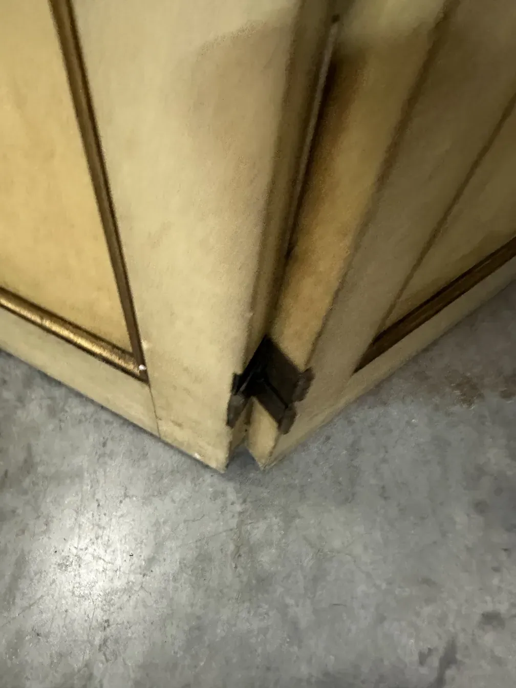 Vista de dos biombos antiguos en un espacio interior con suelo de cemento.