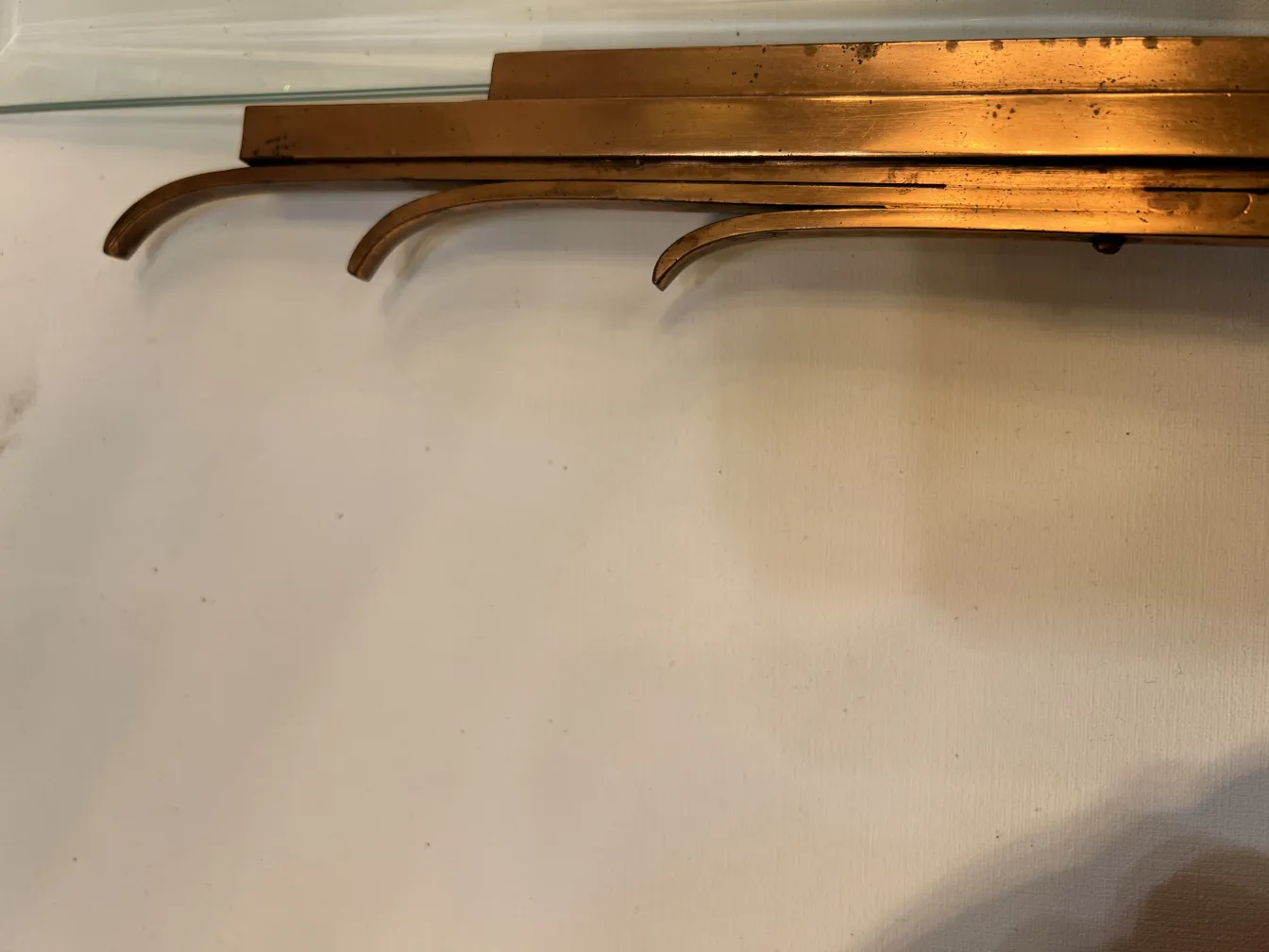 Cadre photo ancien de couleur dorée avec trois supports courbés, simple et élégant