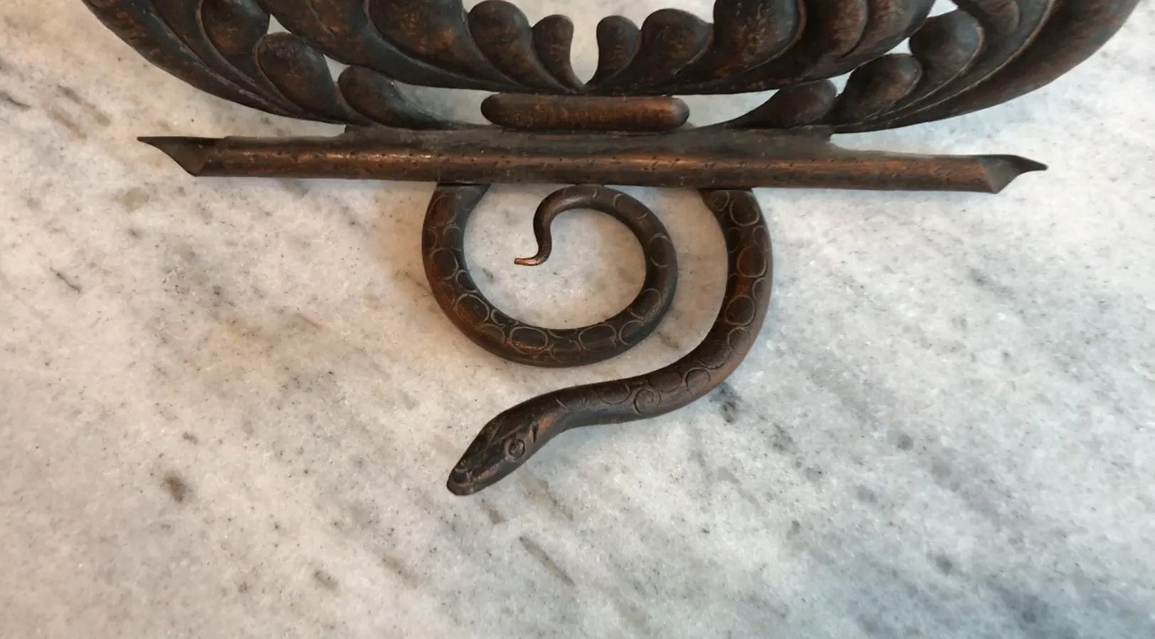 Portafoto antico con design sinuoso e serpentino di colore scuro.