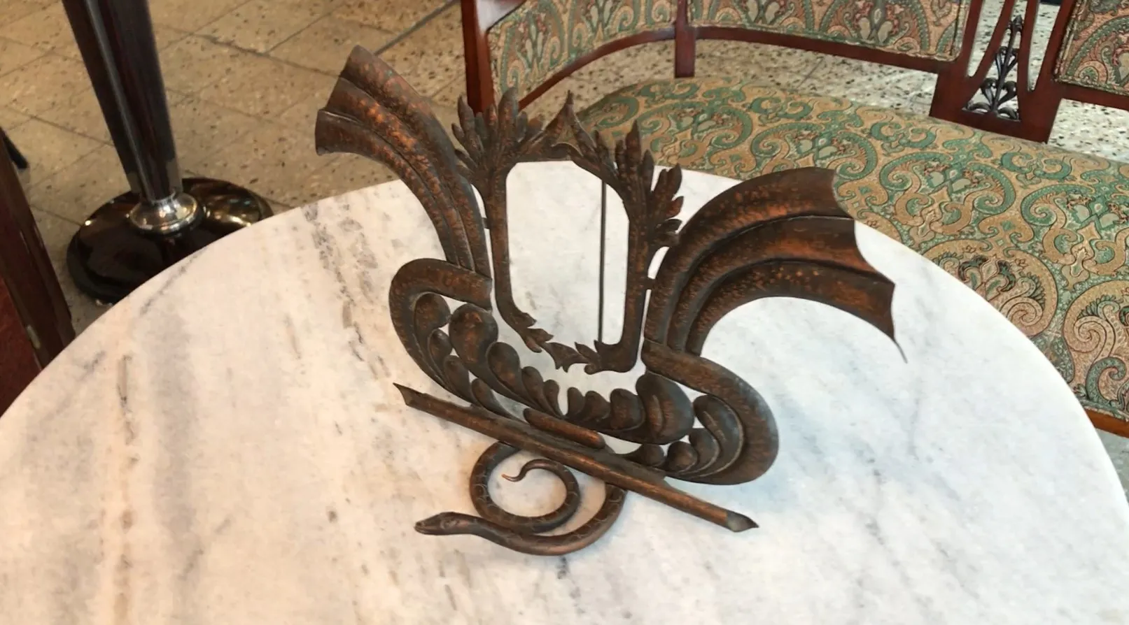 Antique picture frame with decorative design and intricate details on a light surface.