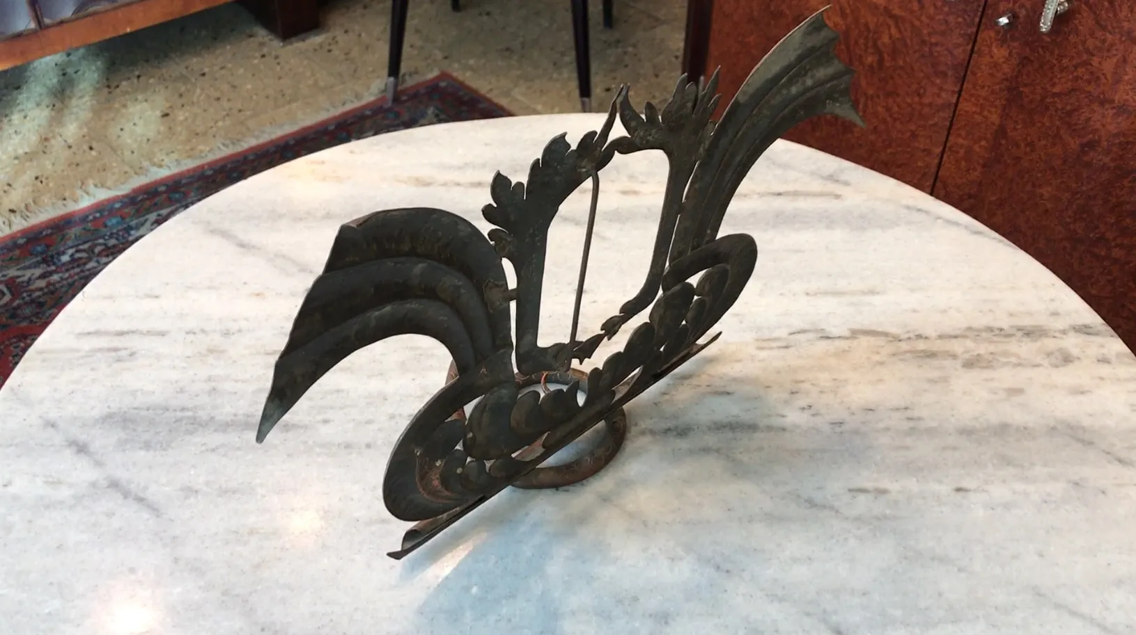 Portafoto antico con design ornamentale e dettagli artistici, posizionato su un tavolo. Sfondo caldo.