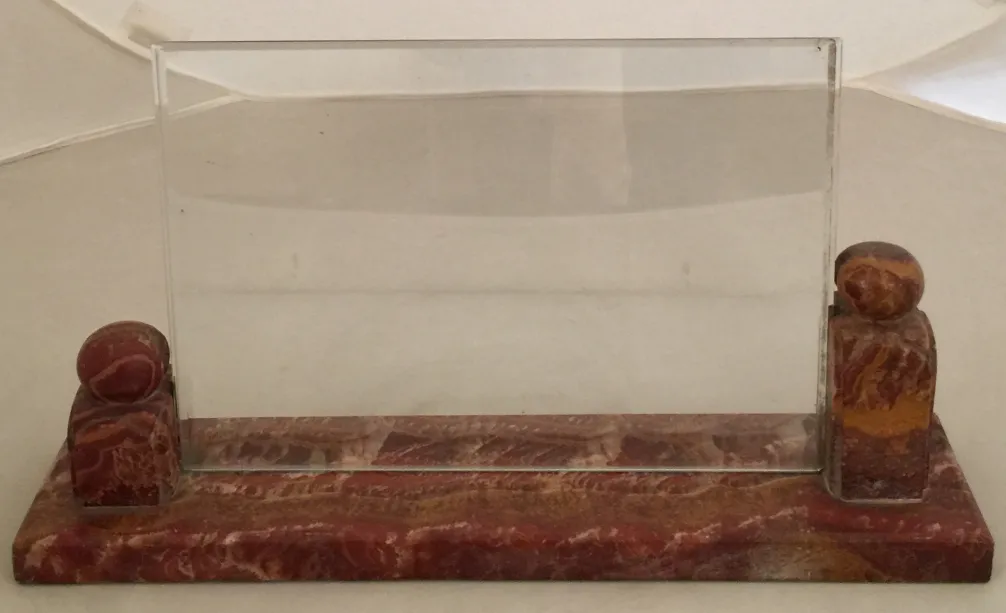 Portafoto antico con supporto decorativo, sfondo chiaro.