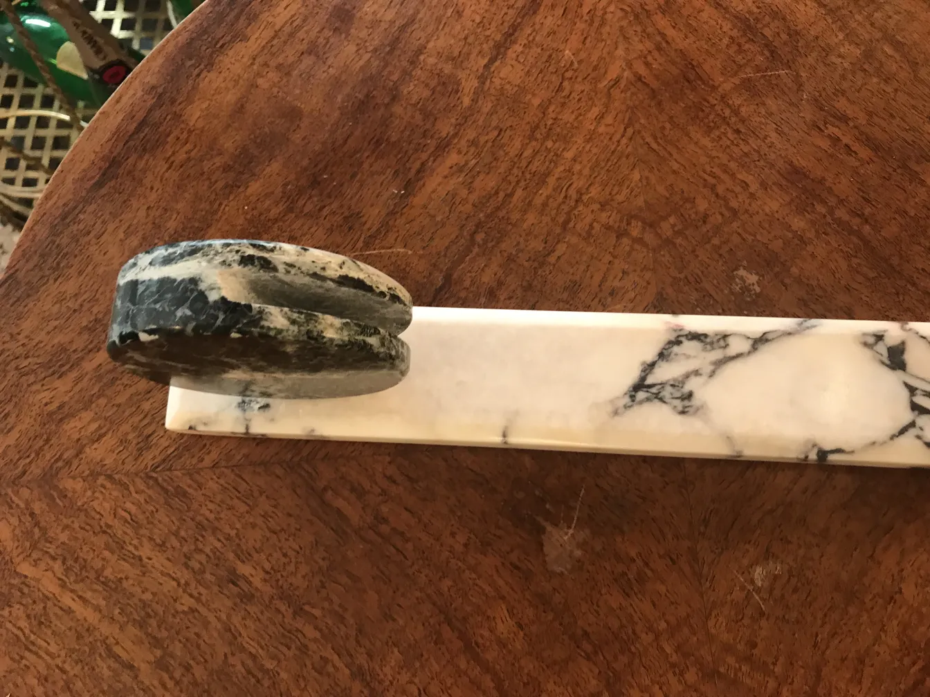 Antique picture frame with a stylized base, featuring light colors.