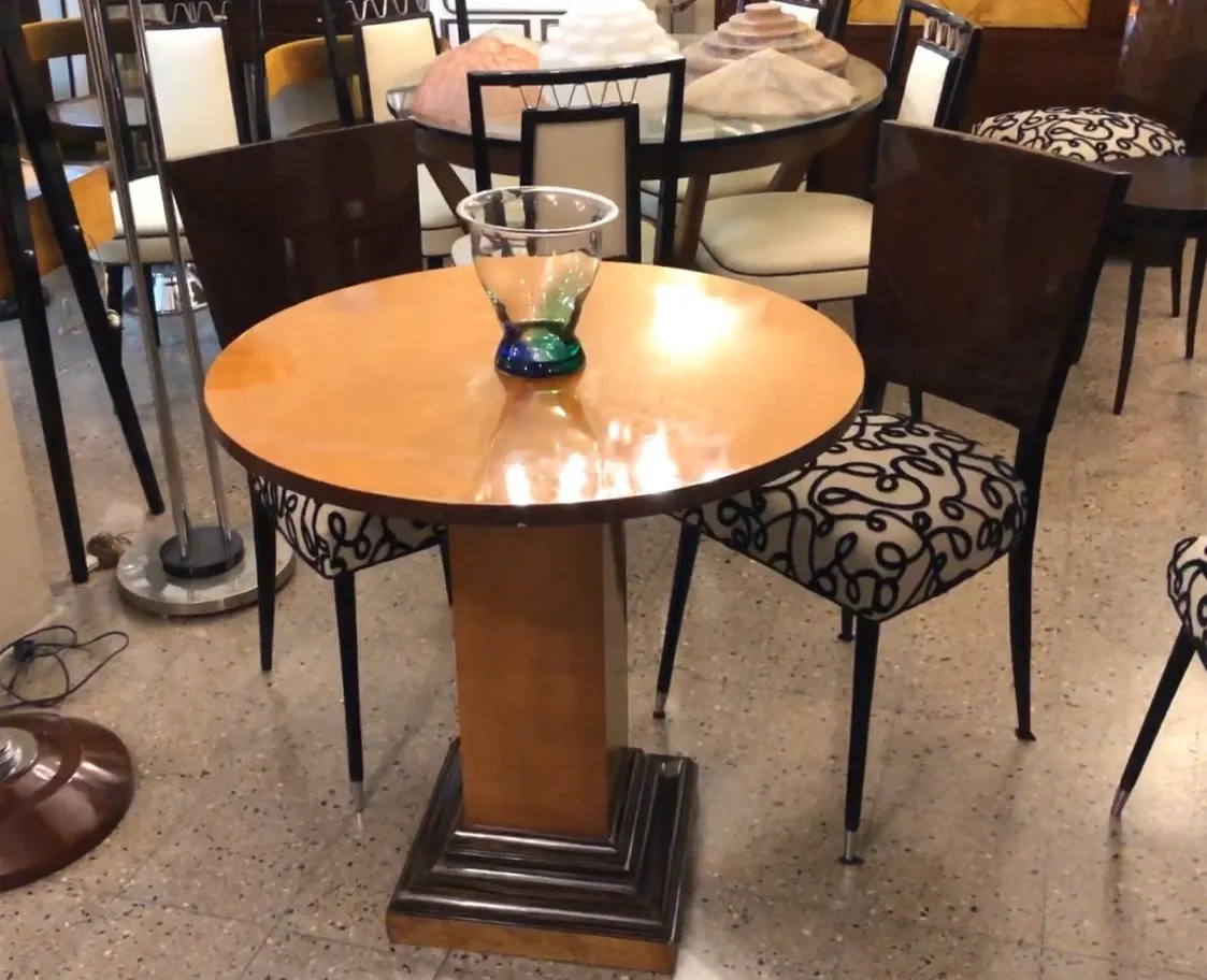 mesa de comedor antigua para dos personas, decorada con un florero colorido