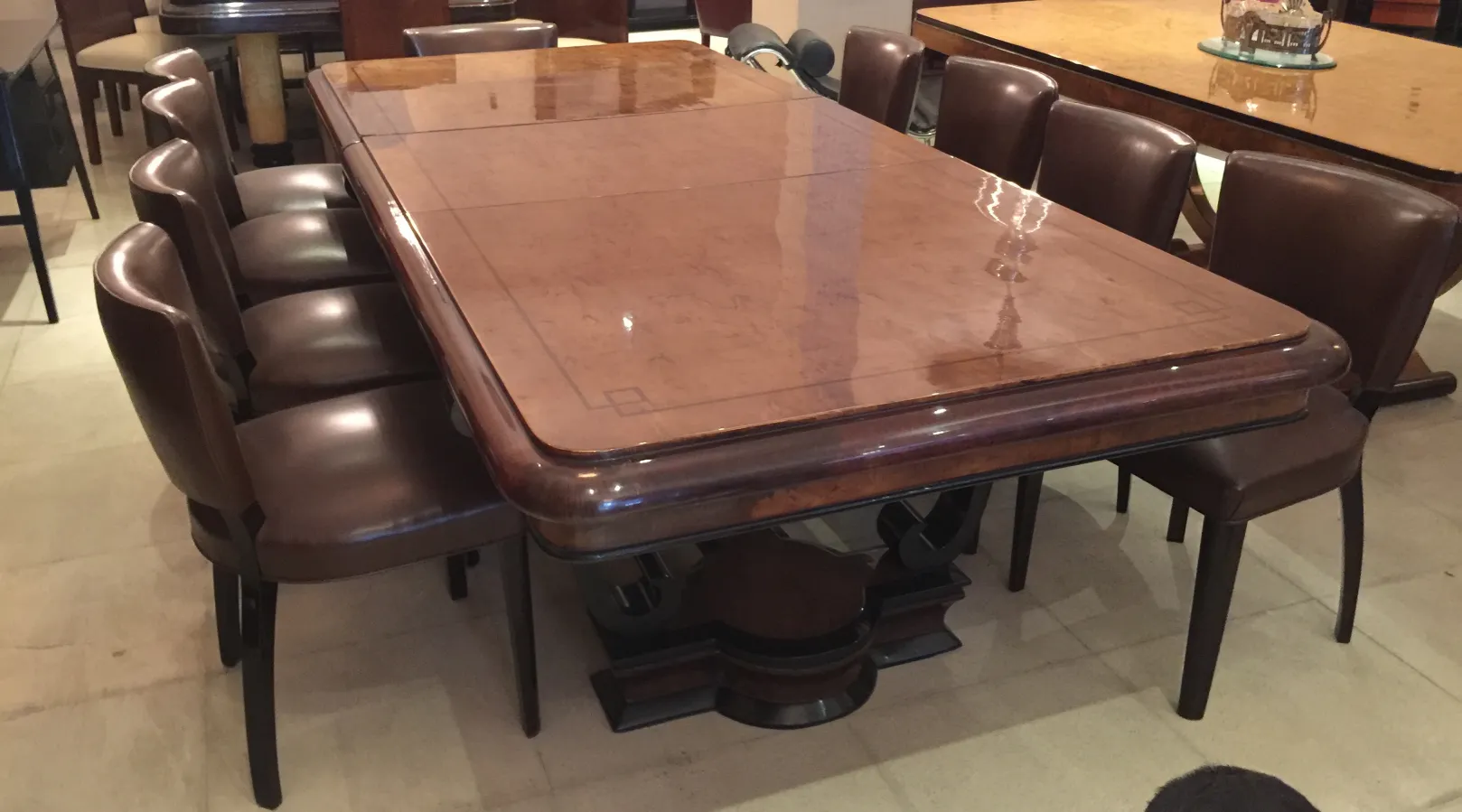 Antique dining table for ten people with chairs in an elegant setting.