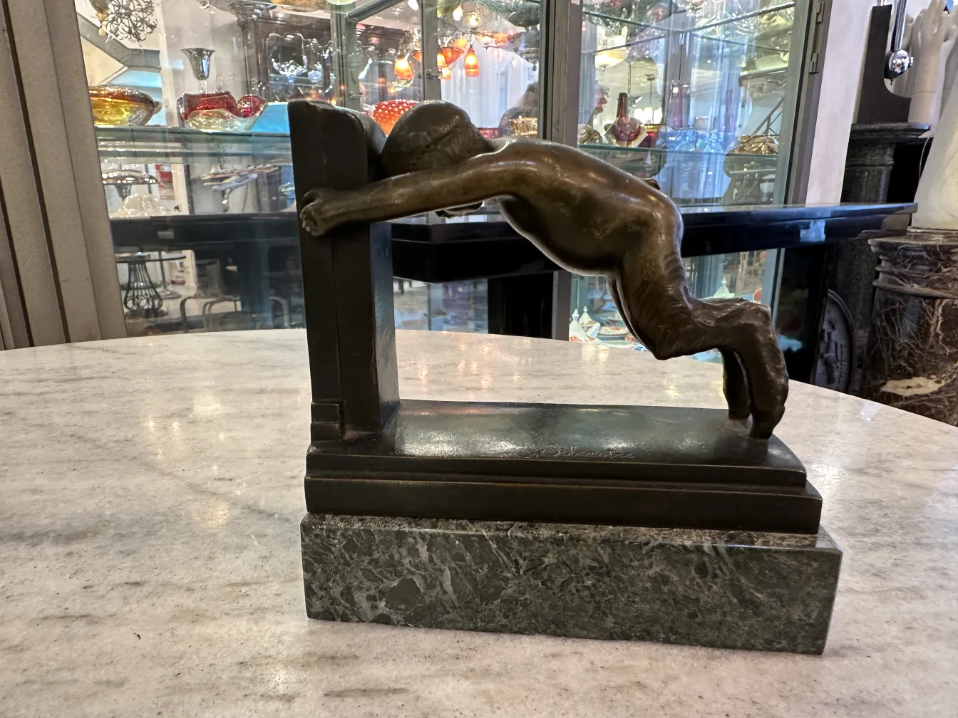 Ancien serre-livres en bronze, figure inclinée, design élégant.