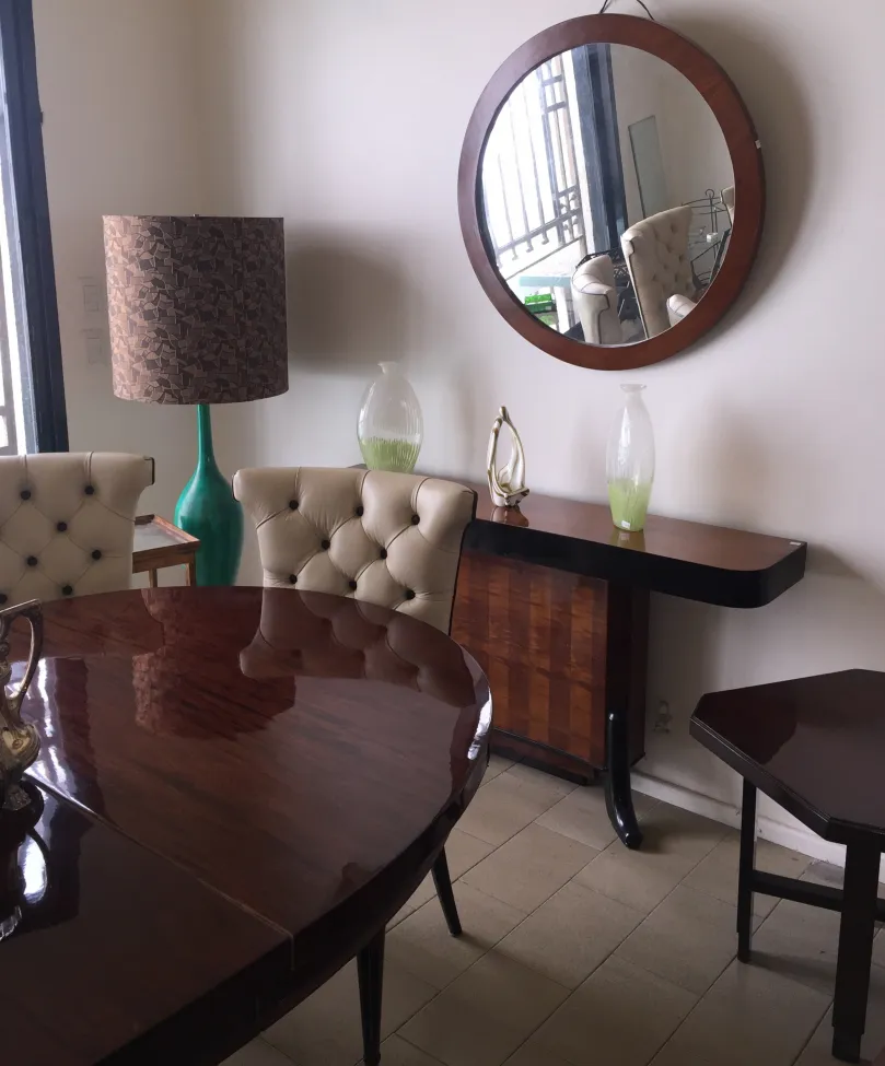 Mesa de jantar antiga para 4 a 8 pessoas com cadeiras bege e decoração moderna.