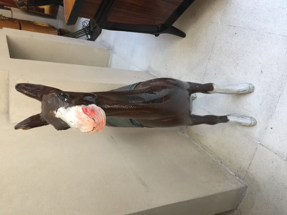 Scultura antica di lama, decorativa, colore marrone, sfondo neutro.