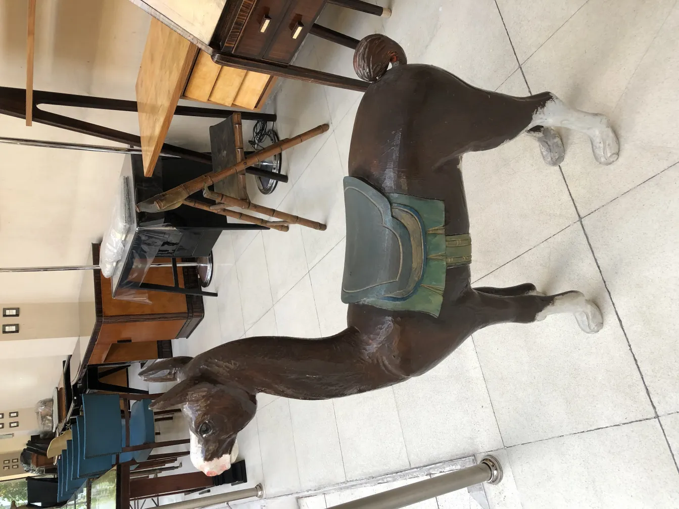 Decorative antique llama with saddle, classic setting.