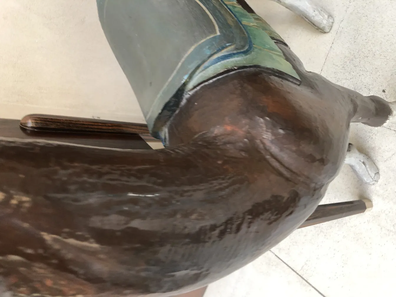 detalhe de escultura antiga de lhama com fundo neutro