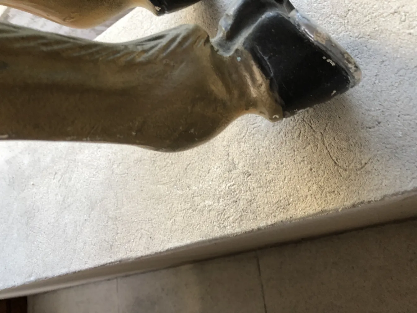 Estatueta antiga de unicórnio com detalhes visíveis na base.