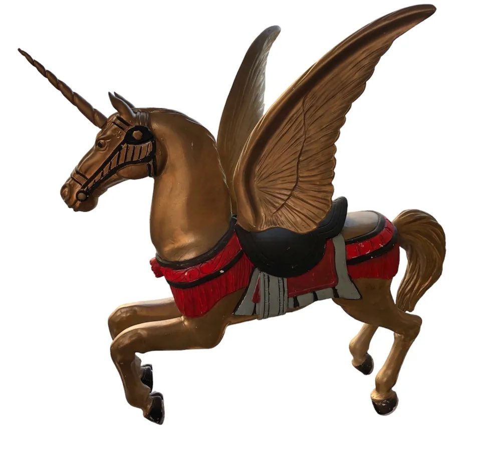 Figurina antica di un unicorno alato in toni dorati.