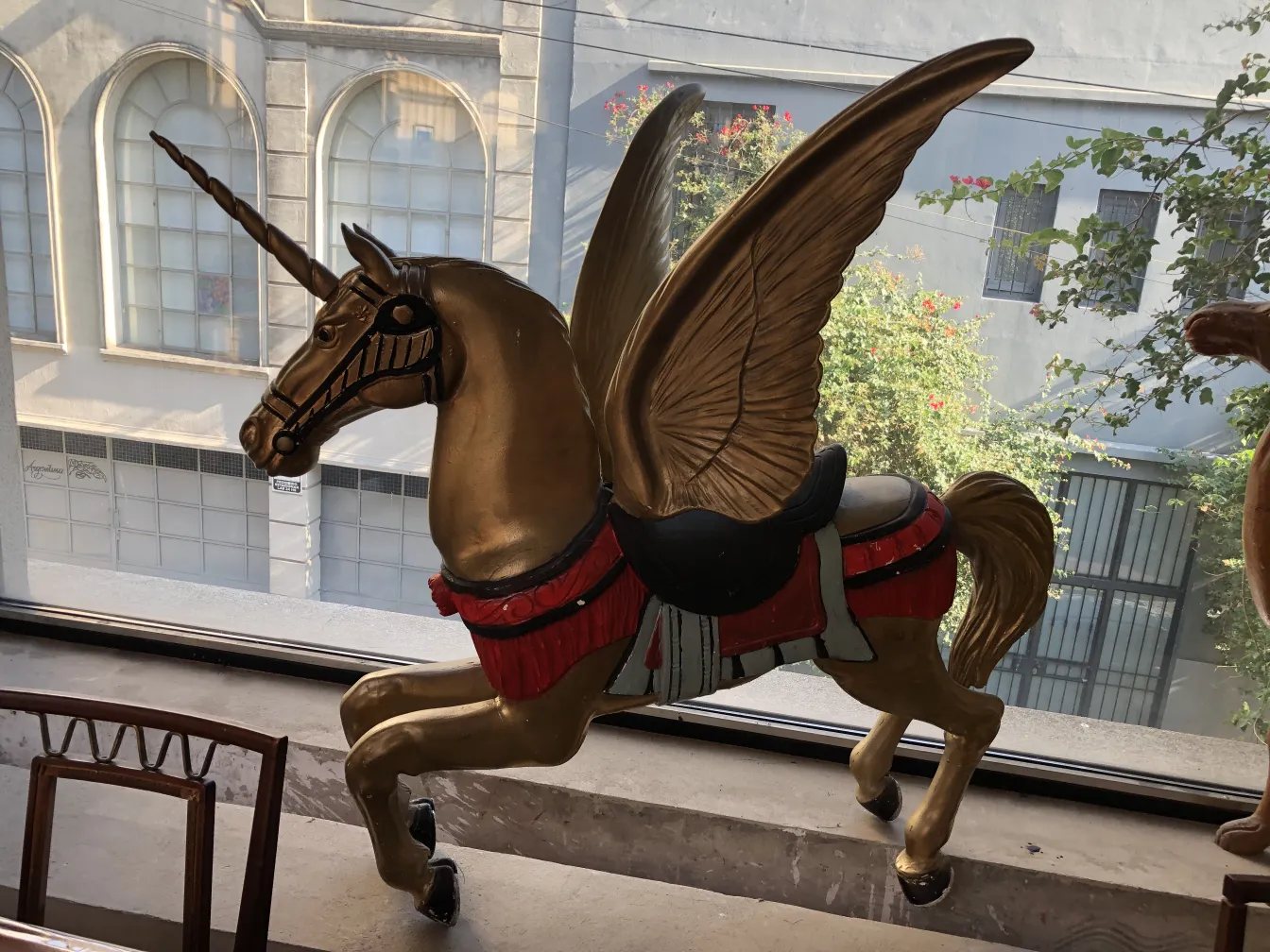 Unicórnio dourado antigo com asas na janela