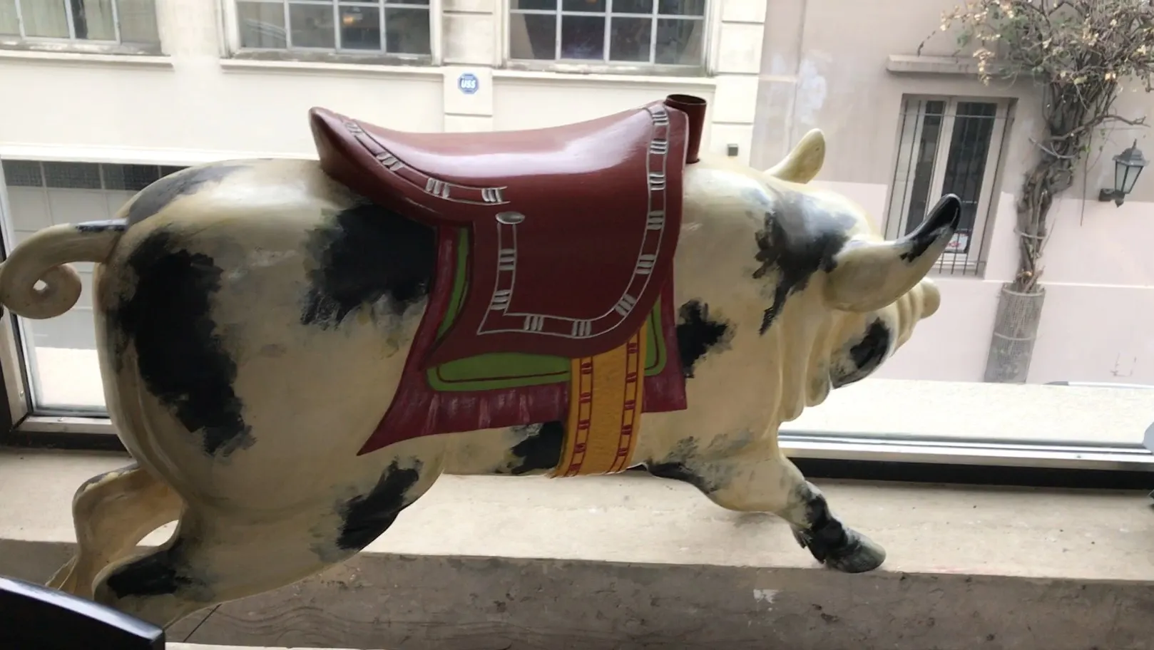 古董猪雕像，红色马鞍，黑色和奶油色。