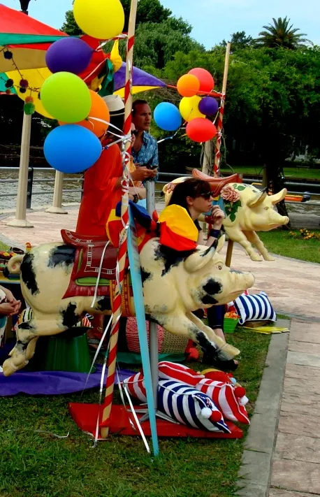 Antiguo juguete de chancho decorado con colores vivos en un ambiente festivo.
