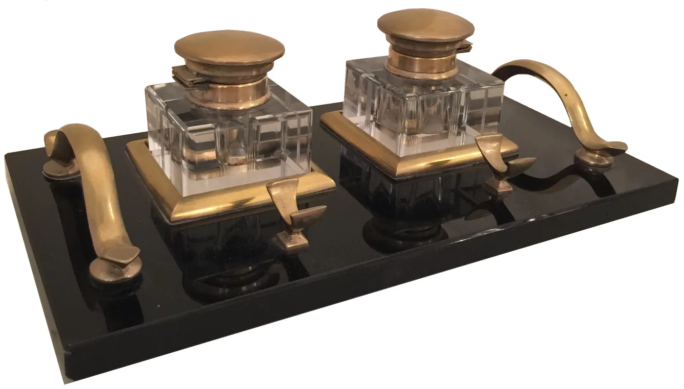 古いインク壺が暗い台の上に二つの容器を持っています