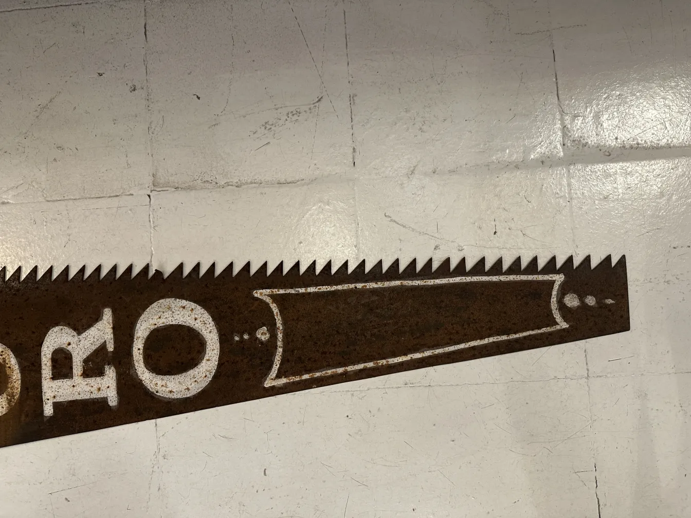 Antique advertising hand saw featuring visible details on blade.