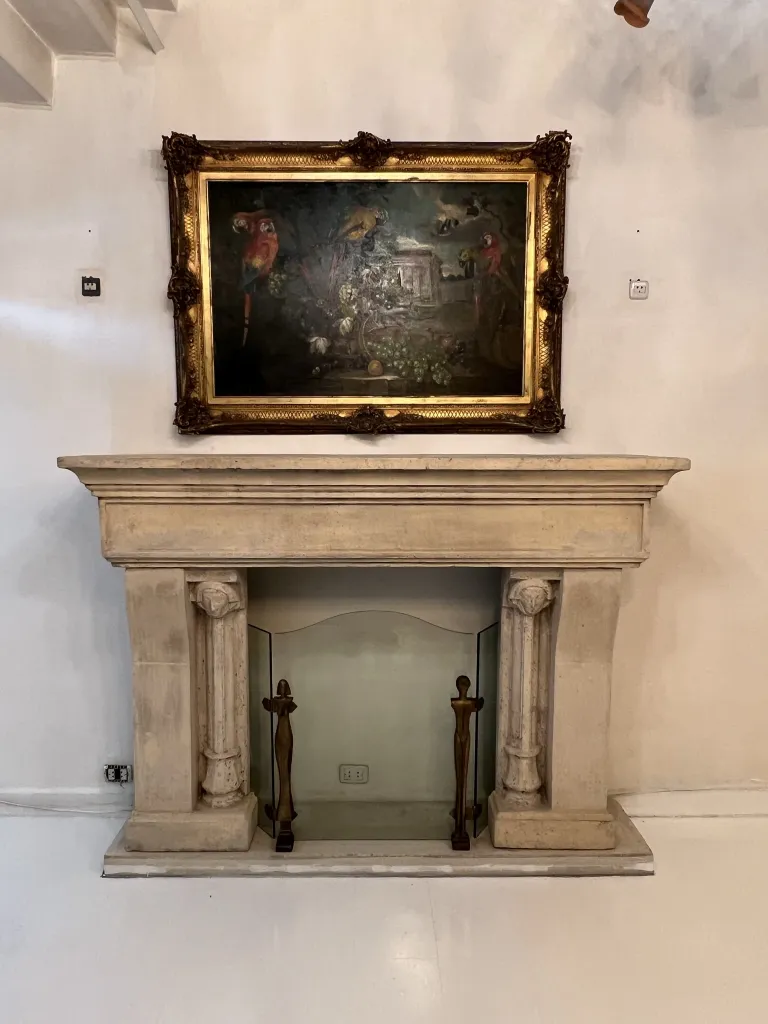 cornice del camino antico con dettagli intricati e una pittura sopra