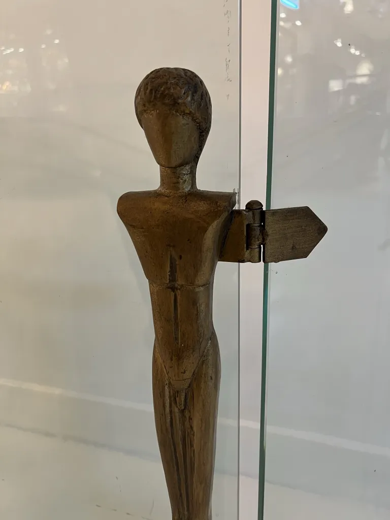 escultura antigua representativa de alberto giacometti en la fachada del hogar, con detalles sencillos y un entorno acogedor.